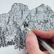 Mano che disegna a penna il monte Pelmo e la chiesetta di Santa Fosca, Val Fiorentina (BL)